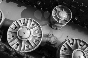 Tank wheels and caterpillar. Closeup black and white photo, heavy industry details