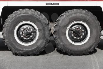 Twin truck wheels on gray asphalt road