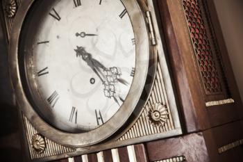 Vintage grandfather clock, decorative wooden body and white dial fragment. Close up photo with warm retro tonal correction photo filter effect