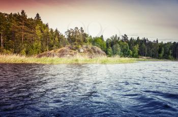 Ladoga lake coastal landscape. Vintage tonal correction photo effect, colorful gradient filter