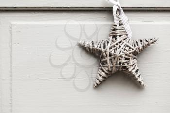 Wicker star hanging on white wooden wall, outdoor decoration background photo texture
