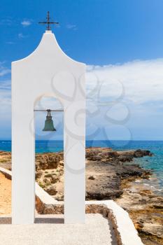 Agios Nikolaos. Small white Orthodox bell tower. Coast of island Zakynthos, Greece