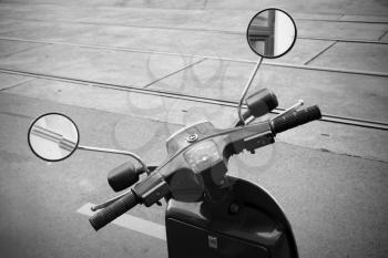 Old Italian scooter handlebar with speedometer and mirrors, sepia toned vintage stylized photo