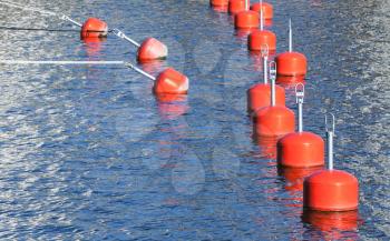 Small red mooring buoys in a row, European marina, nautical equipment