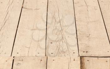 Wooden floor background photo texture, planks jointed with nails. Closeup photo with selective focus and perspective effect