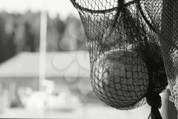 Fishing net fragment with float sphere inside. Black and white photo