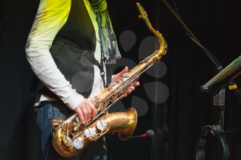 Live music, saxophonist on a stage with colorful illumination
