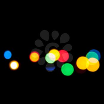 Colorful blurred lights over black background, bokeh optical effect. Abstract photo