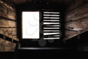 Empty attic window with shutters in old grunge wooden interior