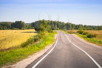 Empty turning rural highway under blue sky, European road, summer landscape