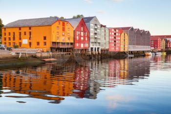 Colorful old wooden houses stand in a row along the river coast. Trondheim, Norway