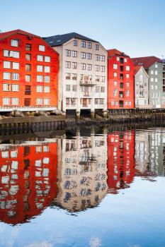 Colorful old wooden houses stand along Nidelva river. Trondheim, Norway
