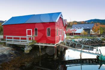 Norwegian red wooden fishing barn stands on the sea coast. Snillfjord, Sor-Trondelag region, Vingvagen village