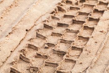 Tire track on wet sand, abstract transportation background photo with selective focus