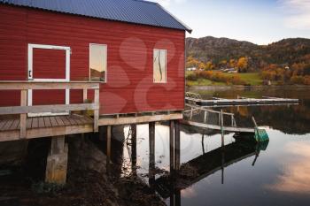 Traditional Norwegian red wooden barn stands on the sea coast. Snillfjord, Sor-Trondelag region, Vingvagen fishing village