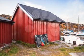 Traditional Norwegian red wooden barns stand on the sea coast. Snillfjord, Vingvagen fishing village