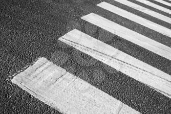 Pedestrian crossing road marking zebra, white stripes over gray asphalt pavement, background photo with selective focus