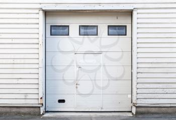 White metal warehouse wall with closed gate, flat background photo texture