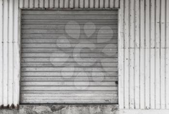 Gray metal warehouse wall with closed gate, flat background photo texture
