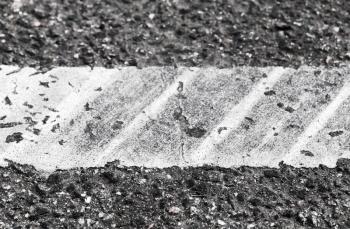 White dividing line with tire tracks over it, highway road marking fragment. Abstract transportation background