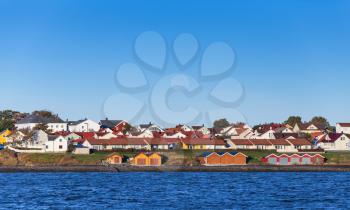 Colorful wooden houses stand on sea coast. Norway, Brekstad