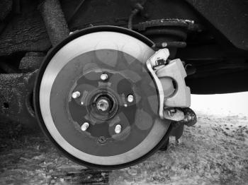 Replacing wheel on modern car, close-up frontal photo of rotor disk with brake and spring, selective focus