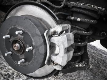 Replacing wheel on modern car, close-up photo of rotor disk with brake and spring, selective focus