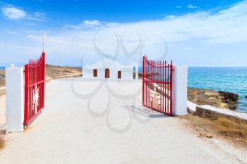 Agios Nikolaos. Open red gate and white Orthodox church on the Sea. Coast of island Zakynthos, Greece