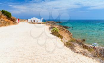 Coastal landscape of island Zakynthos, Greece. Road along Agios Nikolaos beach. Small white Orthodox church