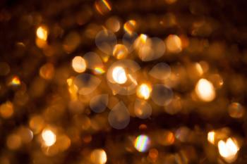 Defocused abstract golden lights background. Natural bokeh photo with rainbow refraction patterns