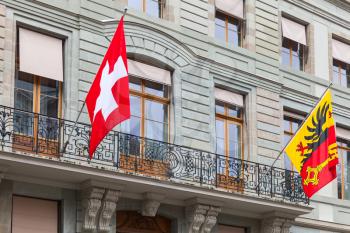 Geneva city, Switzerland. National Swiss and city flags mounted on old house wall
