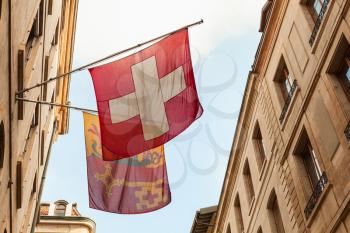 Geneva city, Switzerland. Swiss National and City flags mounted on house wall