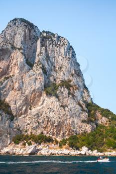 Touristic motorboat goes near coastal rocks of Capri island, Italy