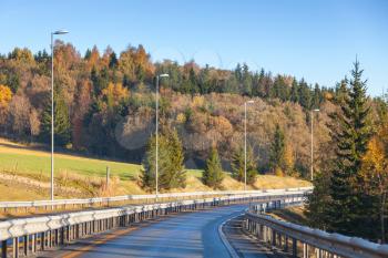 Turning rural Norwegian road in autumn season