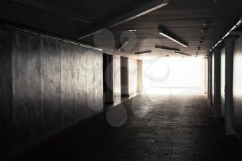 Empty underpass corridor. Dark abstract underground tunnel interior with glowing end