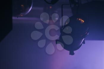Scenic spot light over dark purple background, stage illumination equipment