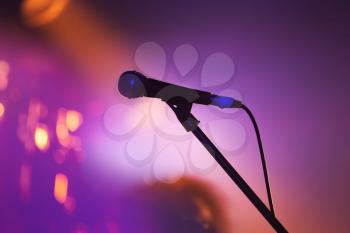 Professional stage microphone over blurred lights colorful background