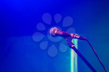 Professional stage microphone over blurred blue background