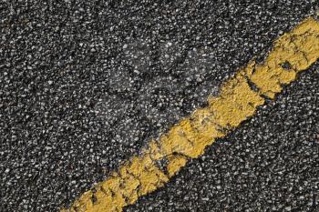 Black asphalt road with yellow dividing line. Transportation background texture