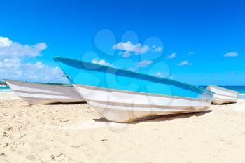 Blue white pleasure boats lay on sand of Macao Beach, coastal landscape. Dominican Republic, Hispaniola Island