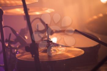 Warm toned live music photo background, drummer plays on rock drum set. Closeup photo, soft selective focus