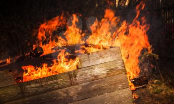 Close-up photo of burning wooden boxes in big bonfire
