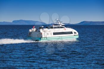 Fast passenger ferry boat goes on Norwegian sea. Trondheim, Norway