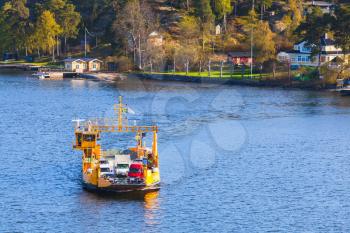 Yellow Ro-Ro cargo ship crossing the bay. Small ferry line near Stockholm, Sweden