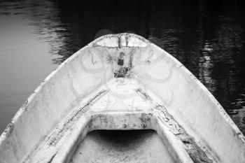 Empty bow of old white grungy rowboat, black and white photo