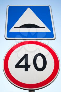 Speed Bump and speed limit. Road signs over bright blue sky background