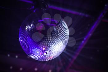 Disco ball with bright purple rays, night party background photo