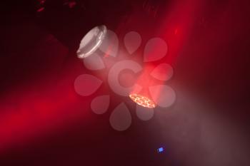 Stage spot lights with red beams in smoke, stage illumination equipment