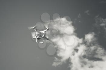 White quadrocopter, small drone controlled by wireless remote, black and white photo