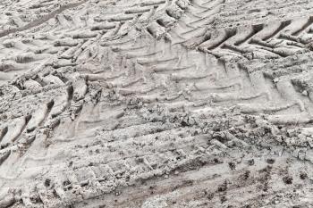 Tractor tire tracks pattern on gray ground, abstract transportation background photo with selective focus